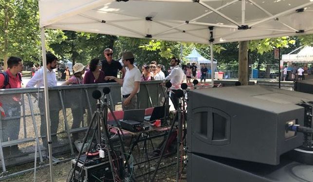 Picture of people at a small fenced area with microphones